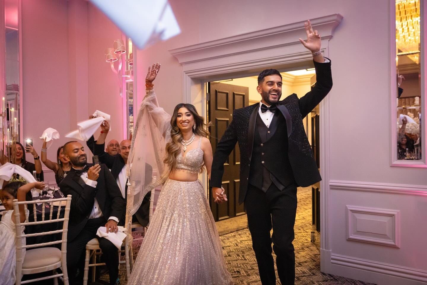 The couple entering the room hand in hand to applause