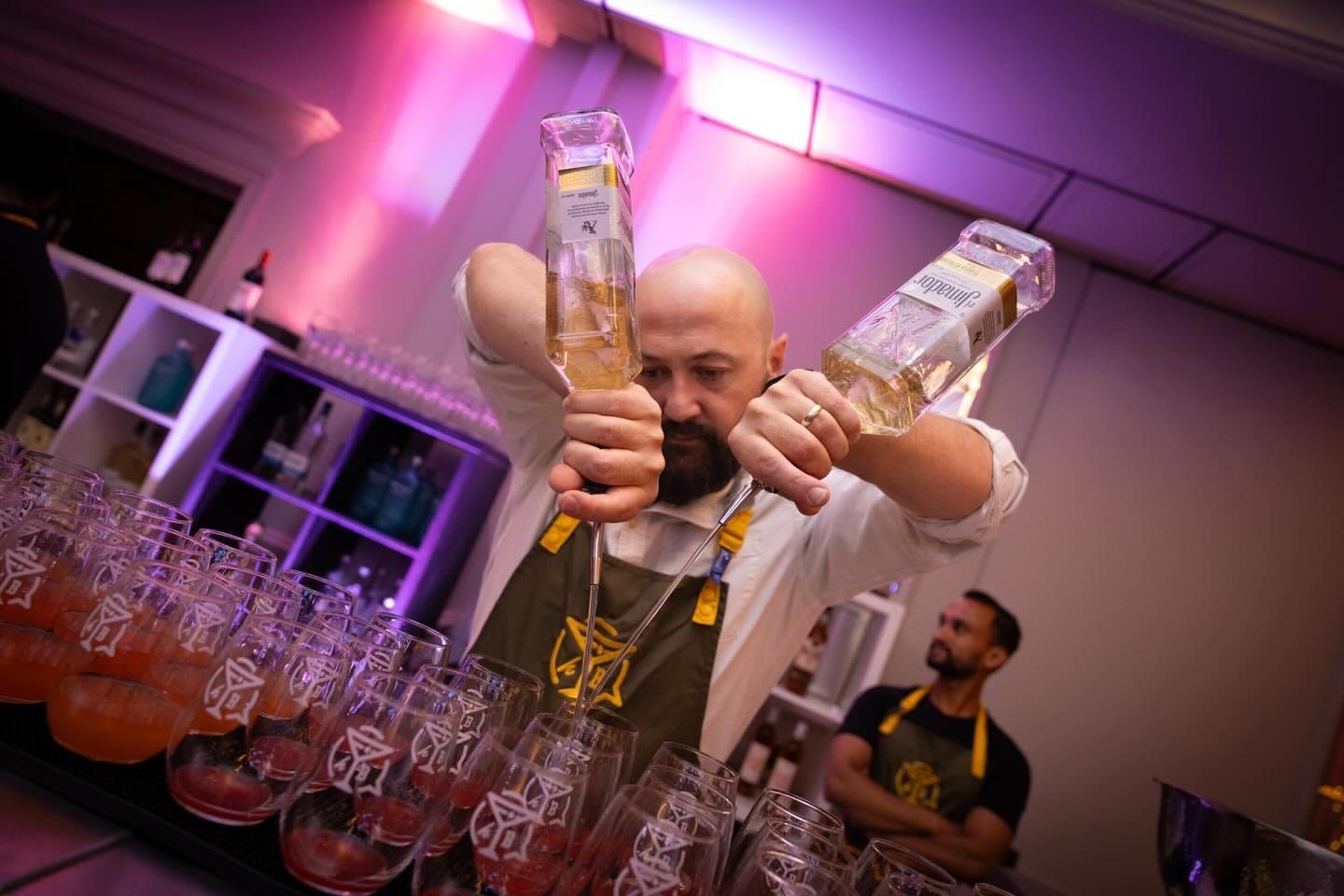 A bartender pouring cocktails at the event bar