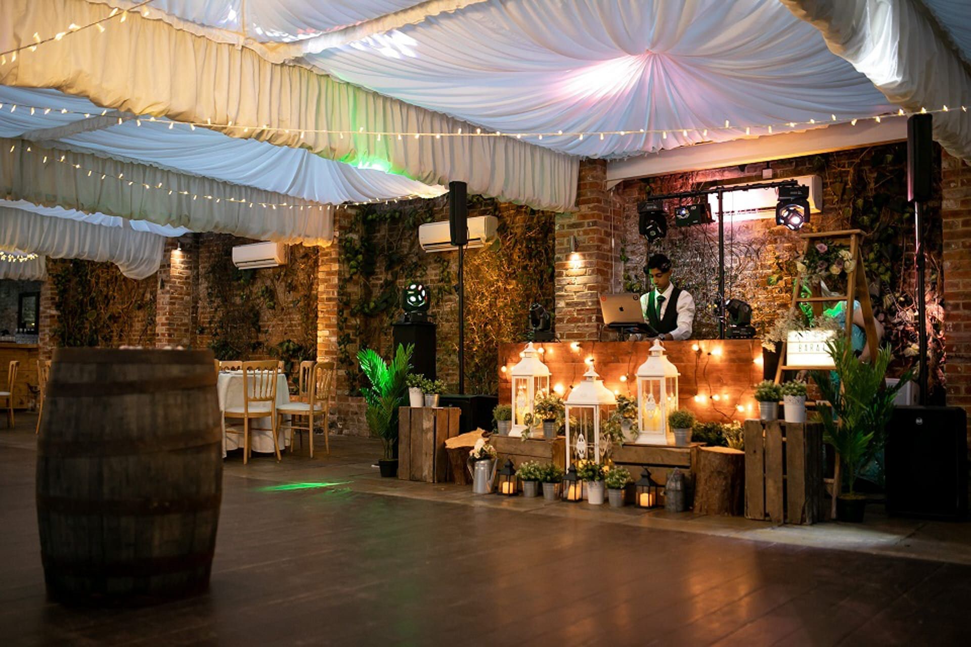 A rustic bar built from reclaimed timber and dressed with lanterns and foliage