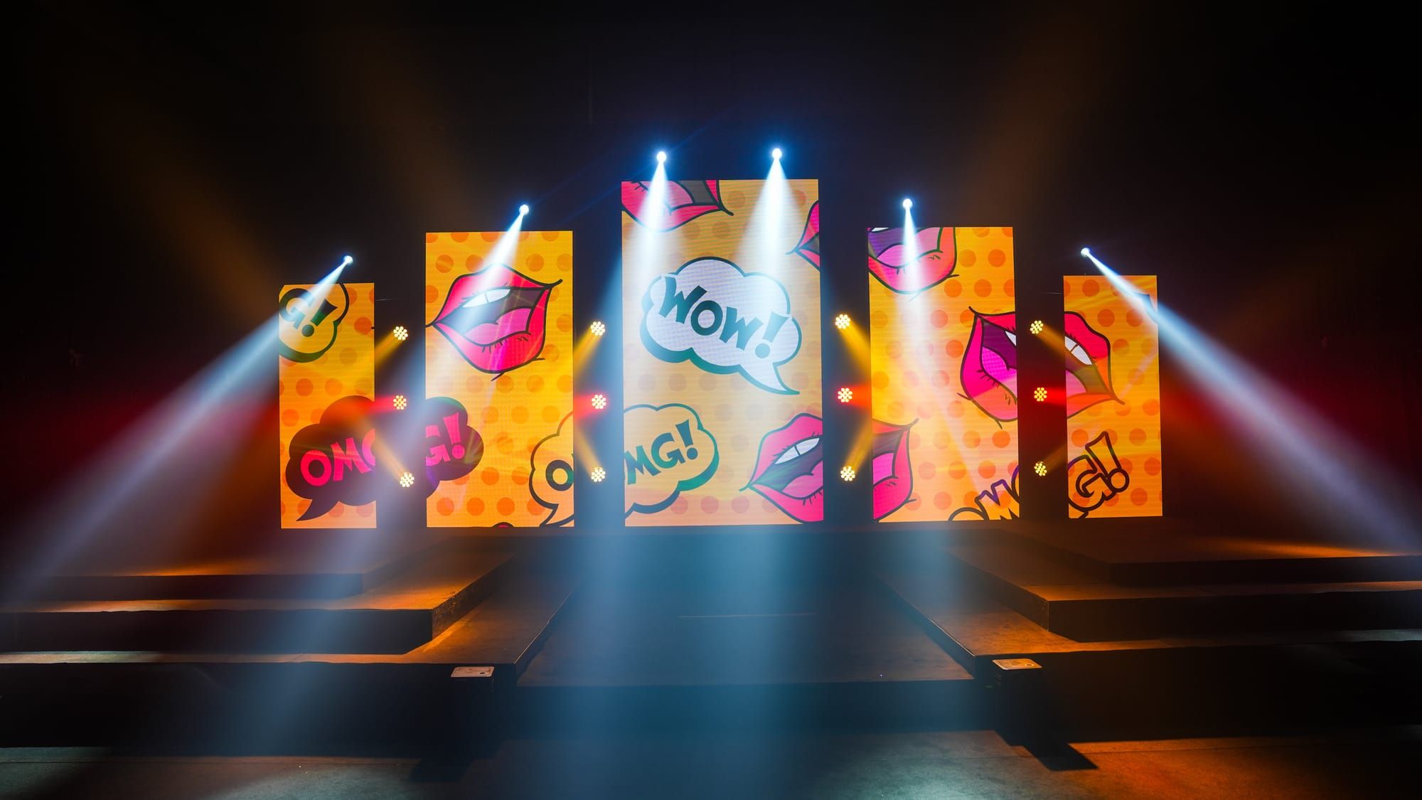 LED panels forming a pop-art backdrop across a runway stage