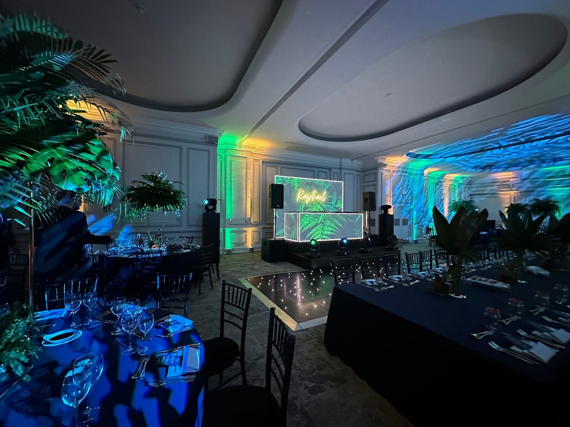 Screens and tropical foliage in a room washed blue and green
