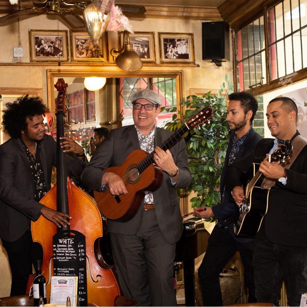 An acoustic trio with double bass and guitars performing among guests