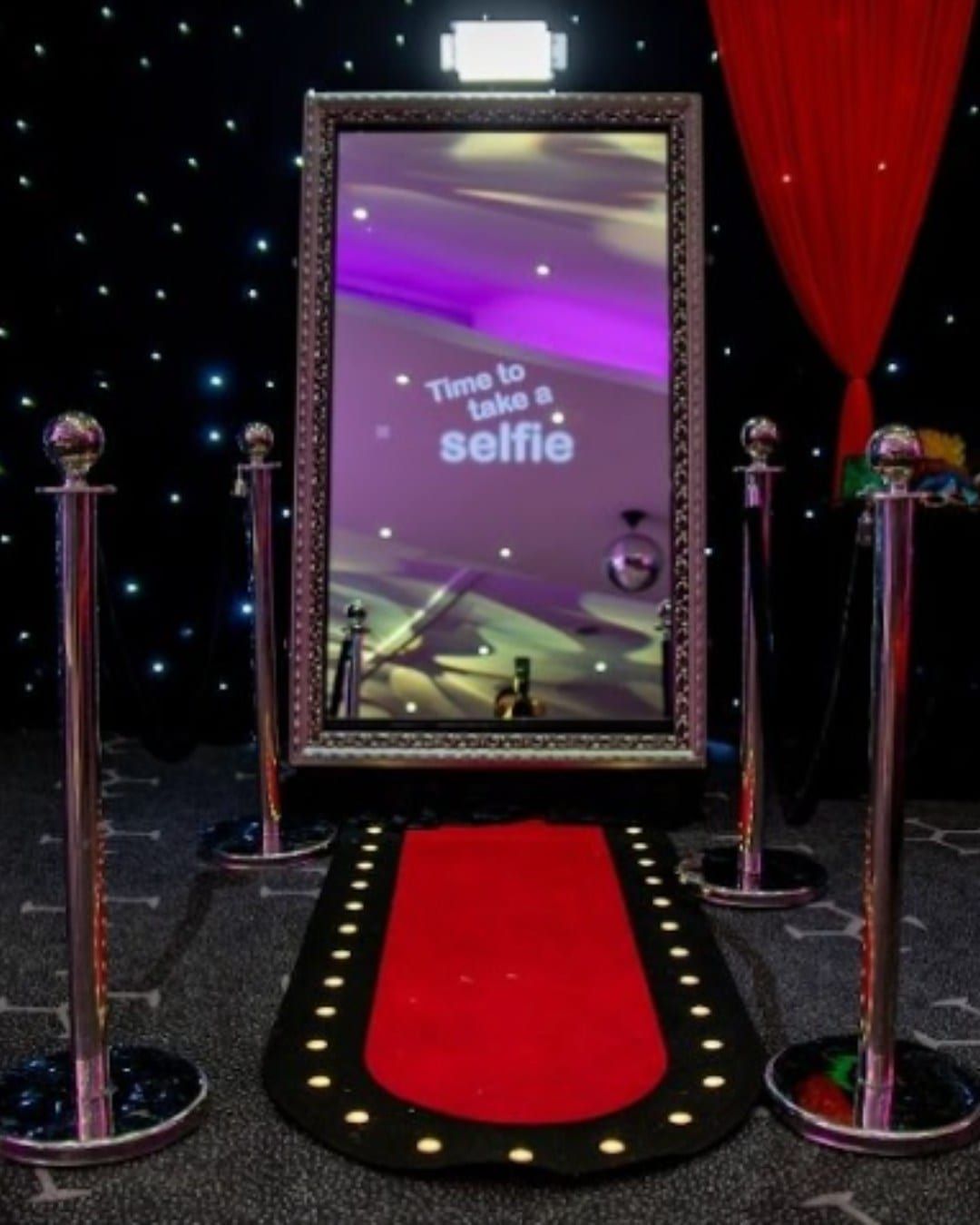 A magic mirror photo booth on a red carpet, prompting guests to take a selfie