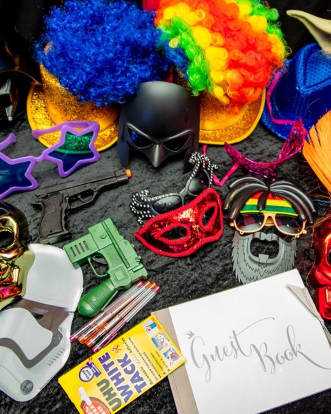 A flat lay of photo booth props: masks, oversized glasses and inflatable toys