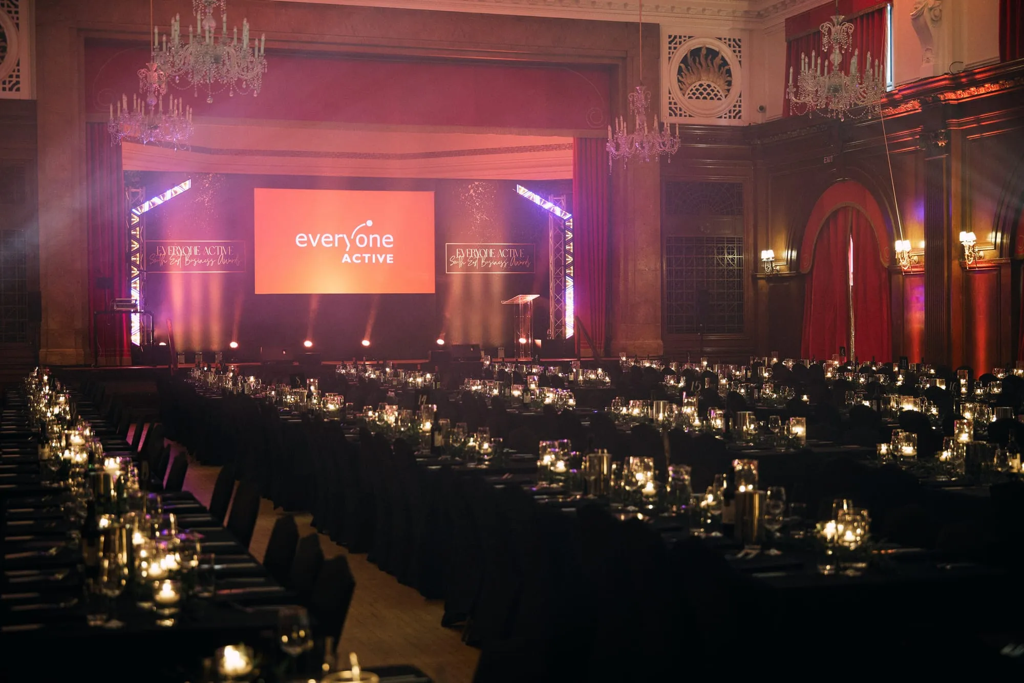 A gala dinner filling a chandeliered hall, tables candlelit end to end