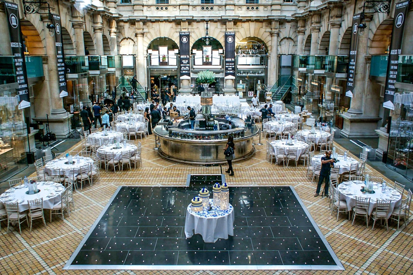 Round tables set around a starlit dancefloor beneath the galleried dome of a historic hall